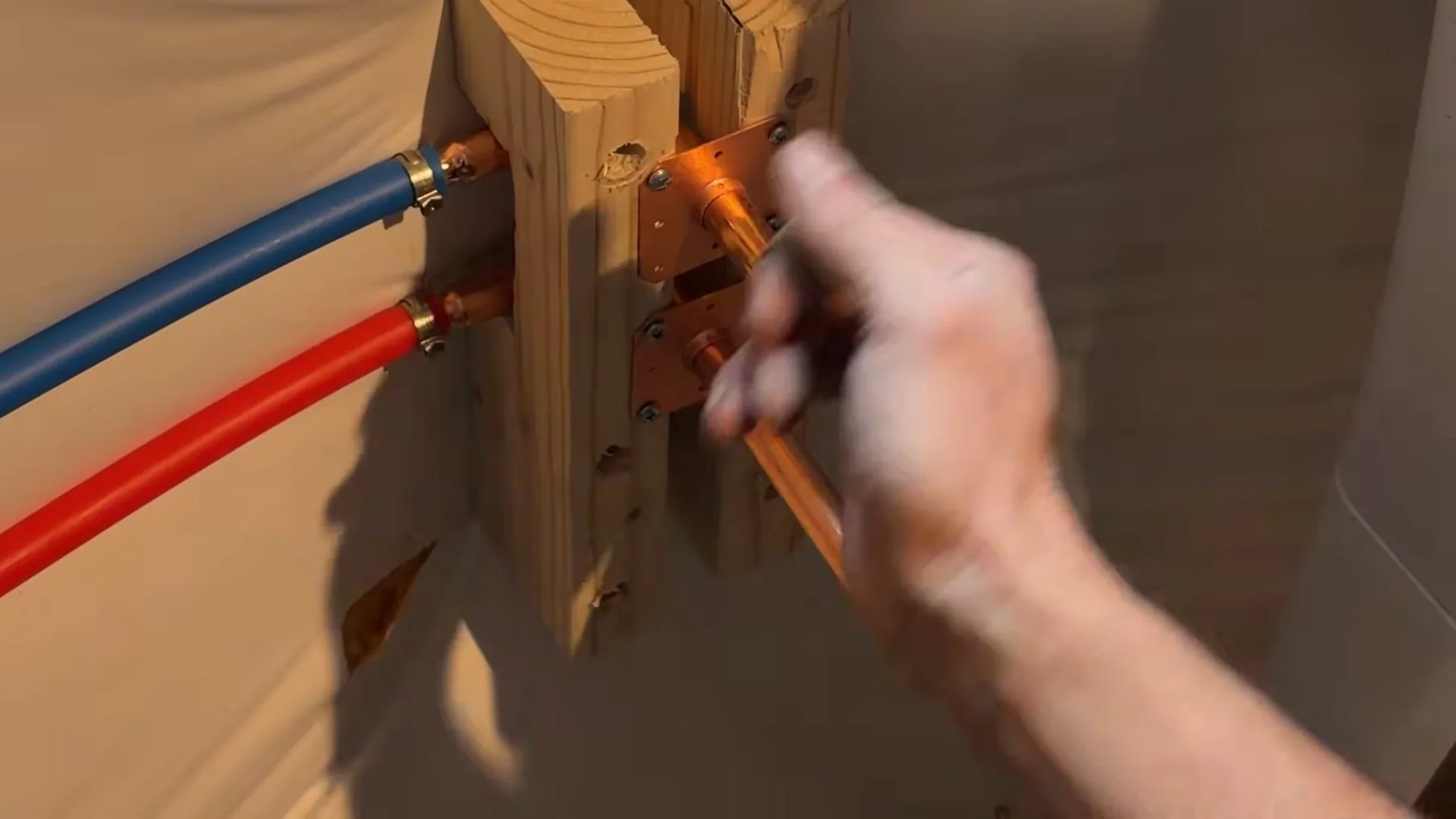 Plumber measuring basement utility sink pipe, photographed on a local plumbing job